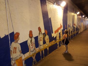 a girl looking at a wall mural