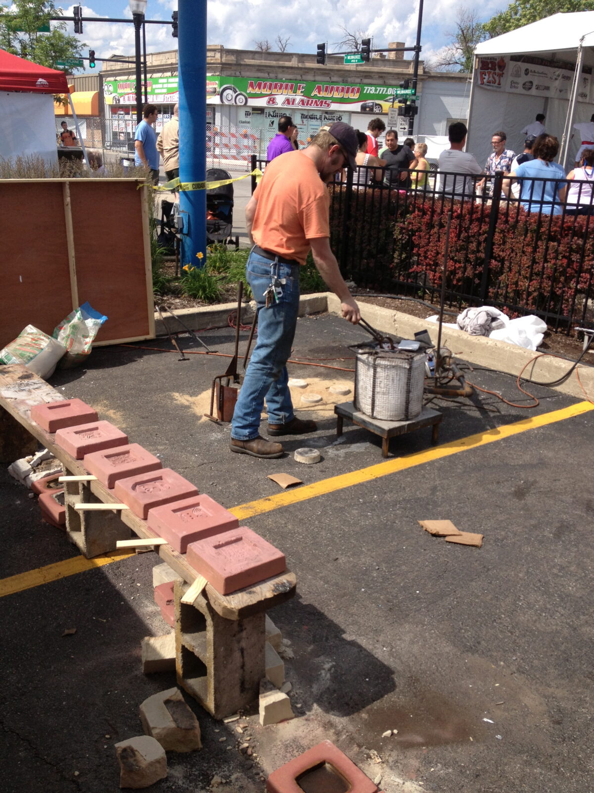 A man is making bricks in a parking lot.