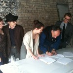 A group of people standing around a table.