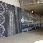 A black and white mural of a dna on an underpass.