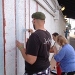 A group of people painting a wall.