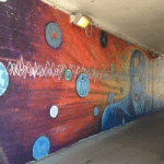 A mural painted on the side of an underpass.