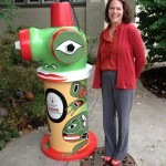 a woman next to a fire hydrant with a lizard design