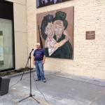 a man standing in front of a wall mural