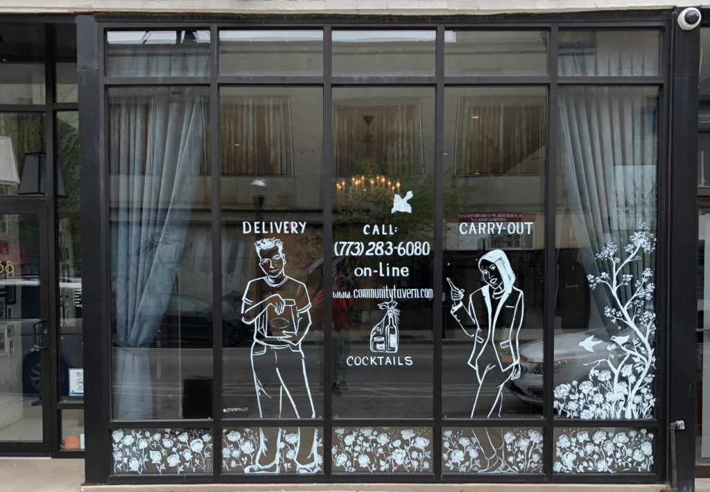 Storefront window with delivery and carry-out signs.