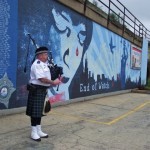a man playing a bagpipe by the end of watch wall mural
