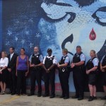 a row of people standing in front of a wall mural