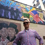 a man with two murals behind him