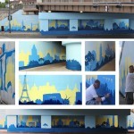 a man painting a mural under a bridge