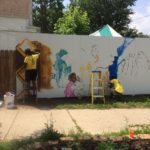 people creating a mural