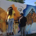 two people painting a mural