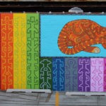 A mural of a cat and rainbow stripes.