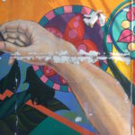 Colorful mural with abstract arm design.