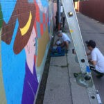 people working on a mural