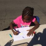 A girl drawing on a piece of paper.