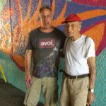 A man standing in front of a colorful wall.