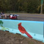 A blue barrier with a red cardinal painted on it.