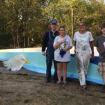 A group of people standing next to a painted eagle.