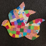 A colorful dove made out of pieces of paper.