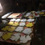 A table full of yellow and white paper cut outs.