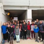 A group of people posing for a picture under an overpass.