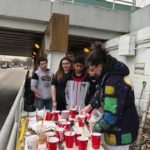 A group of people standing around a table with cups.