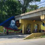 A colorful mural on the side of a bridge.