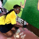 a girl painting a mural