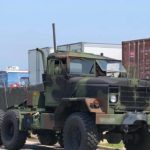 A large military truck is parked on the side of the road.