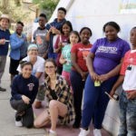 A group of people posing in front of a wall.