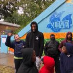 A group of children standing in front of a mural.