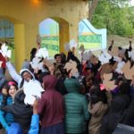 A group of people holding up signs in front of a building.