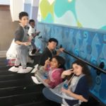 A group of children are sitting on the escalator.