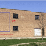 Brick building with measurements on wall.