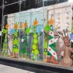 A window display with a group of people dressed up for the holidays.