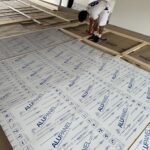 A person inspects insulated panels during construction.